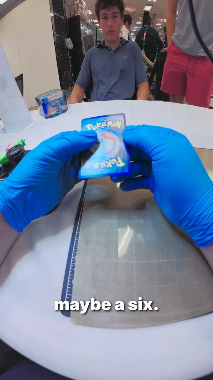A Will it 10? video: a collector watches as a gloved hand checks his Rayquaza card