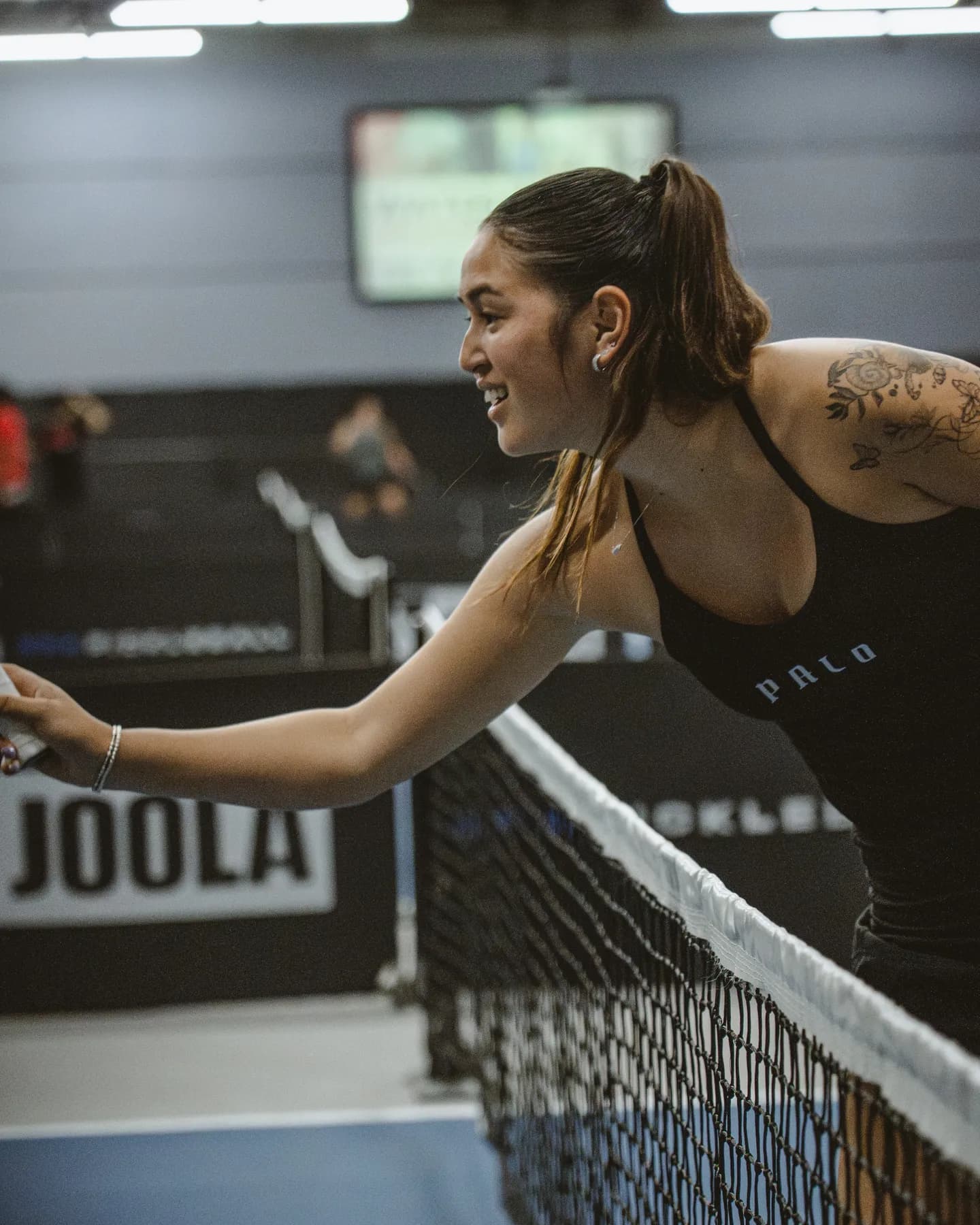 A Palo Pickleball player reaching at the net